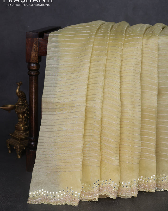 Pure organza silk saree pale yellow with allover zari weaves and sequin mirror work border