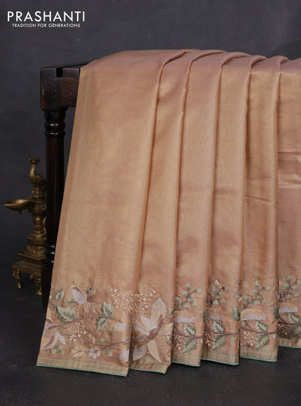 Tissue silk sare golden peach and pastel green with plain body and embroidery work border