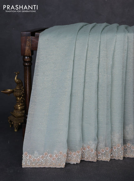 Crush tissue saree pastel green shade with allover stone work and sequin embroidery pallu & border