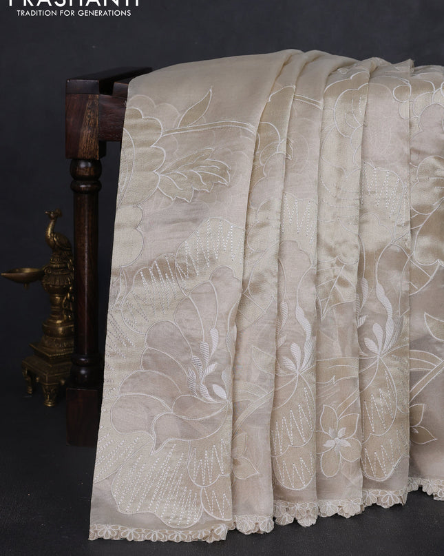 Tissue silk saree off white with allover floral applique work and embroidery border