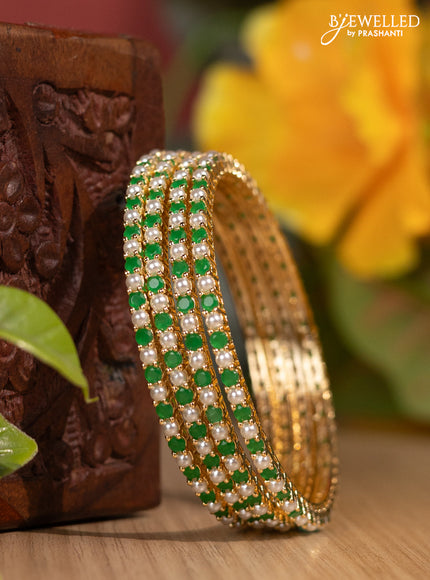 Pearl bangles with emerald stones and pearls in gold finish