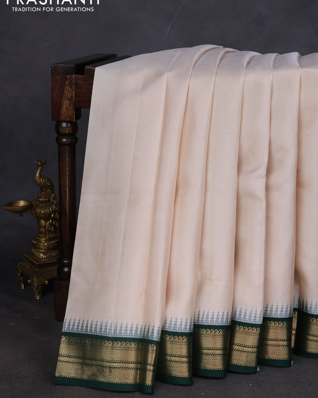 Pure kanchipuram silk saree off white and dark green with plain body and temple design zari woven border