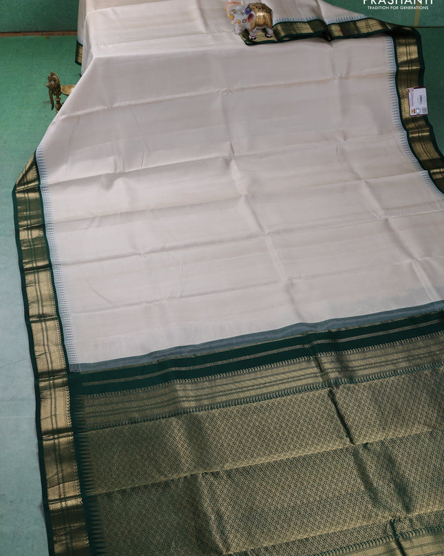 Pure kanchipuram silk saree off white and dark green with plain body and temple design zari woven border