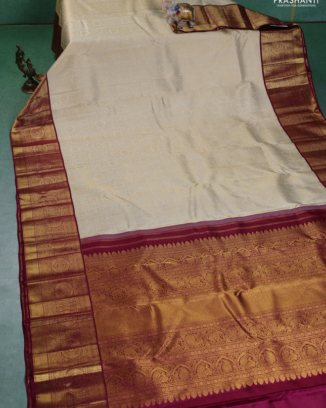 Pure kanchipuram silk saree cream and maroon with allover zari woven brocade weaves and zari woven korvai border