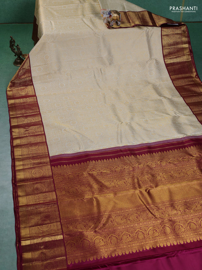 Pure kanchipuram silk saree cream and maroon with allover zari woven brocade weaves and zari woven korvai border