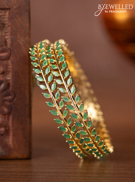 Zircon bangles with emerald stones in gold finish