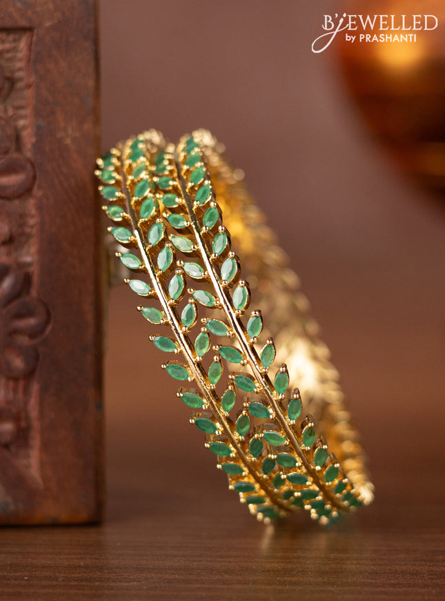 Zircon bangles with emerald stones in gold finish