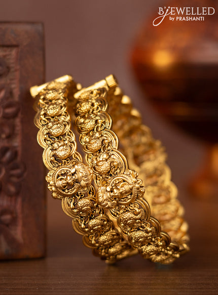 Antique screw type bangles with lakshmi and peacock design